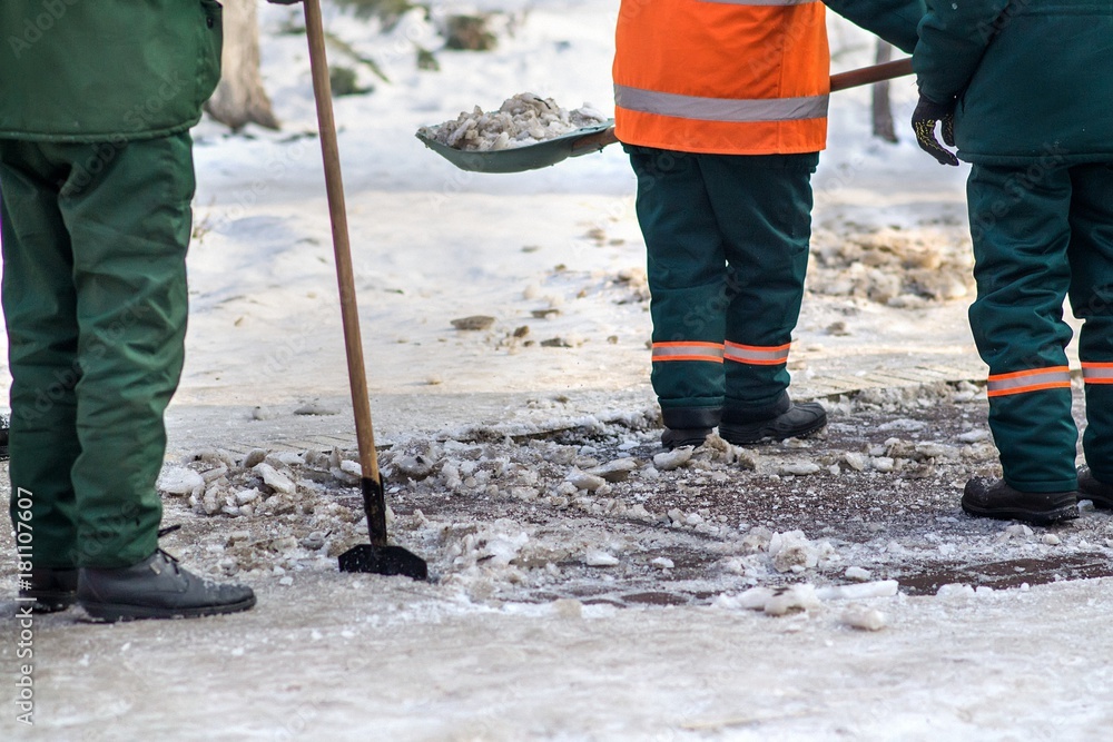 Workers sweep snow from road in winter. Cleaning road from snow storm Workers sweep snow from road in winter. Cleaning road from snow storm