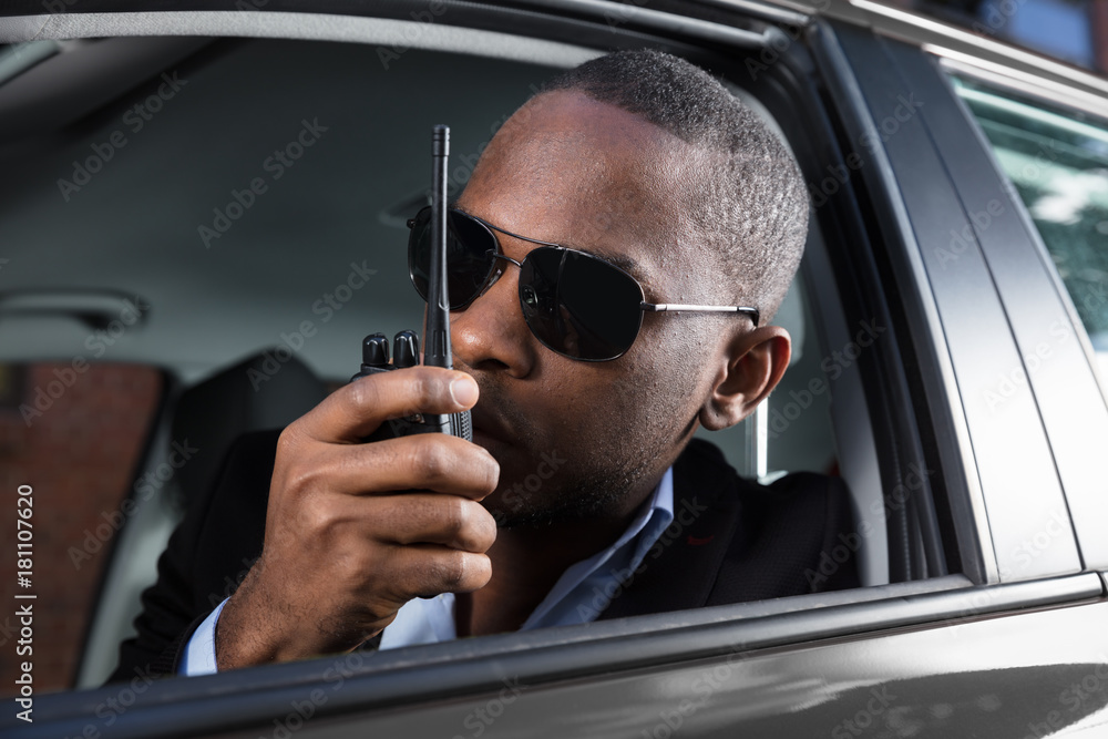 Man Sitting Inside Car Talking On Walkie Talkie