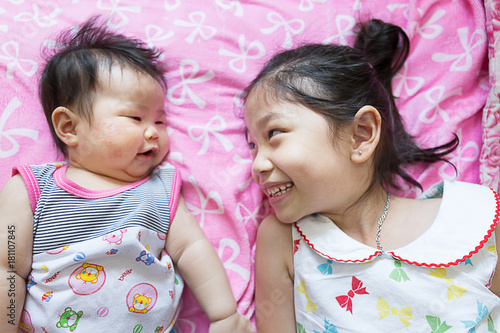 Close up Portrait of a sian cute Infant baby girls with sister