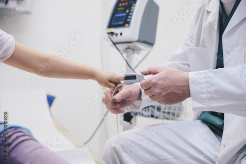 Wallpaper Mural Midsection of mature doctor adjusting pulse oxymeter on girl's finger at hospital Torontodigital.ca