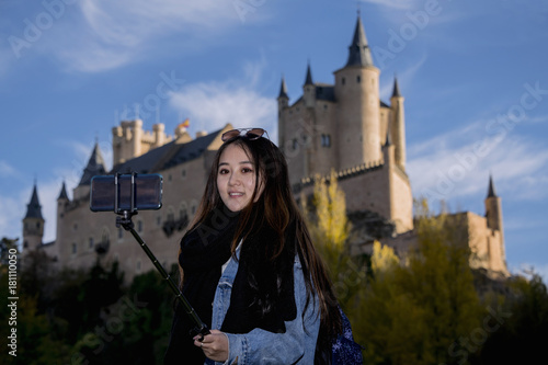 Young oriental, a photo is taken, with the Alcazar de Segovia in the background.