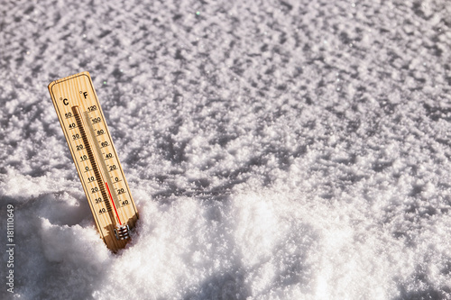 thermometer with a temperature above zero in the snow