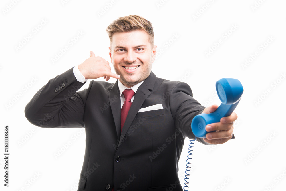 Business man holding blue telephone receiver showing contact gesture Business man holding blue telephone receiver showing contact gesture