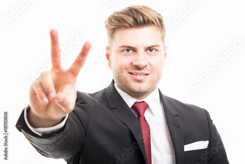 Portrait of business man showing peace gesture