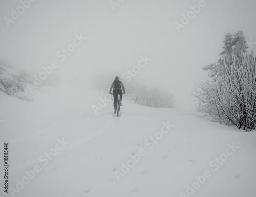 Mountain biker riding bike on the snowy trail