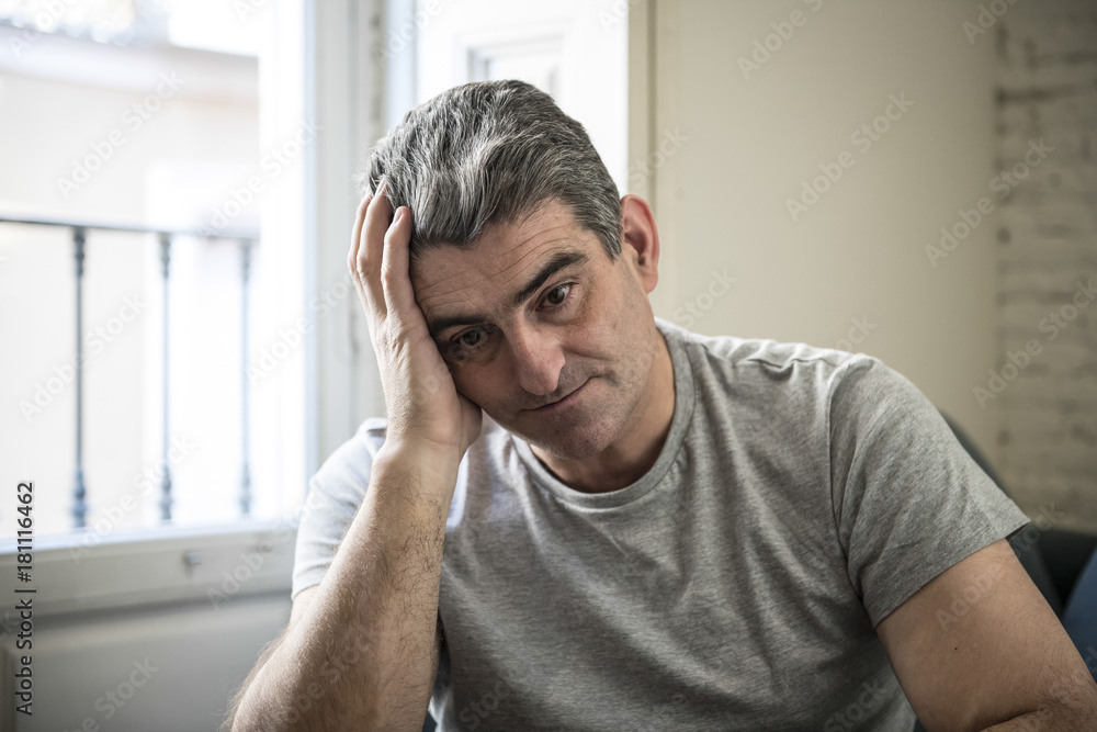 sad and worried man with grey hair sitting at home couch looking sad and worried man with grey hair sitting at home couch looking