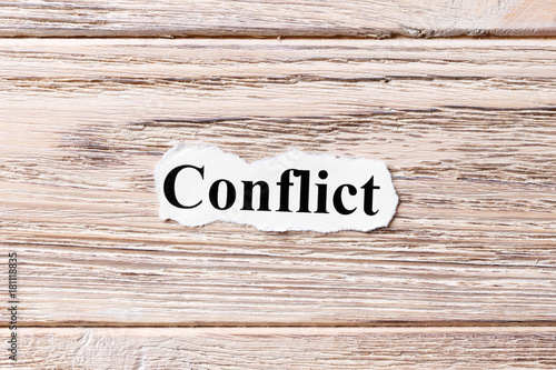 Conflict of the word on paper. concept. Words of Conflict on a wooden background