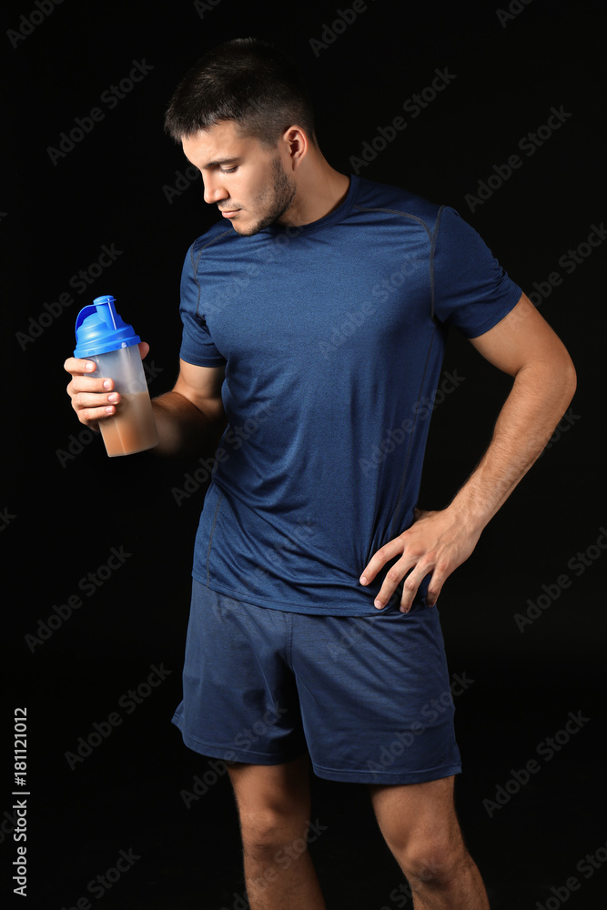 Handsome young man with protein shake on black background Handsome young man with protein shake on black background