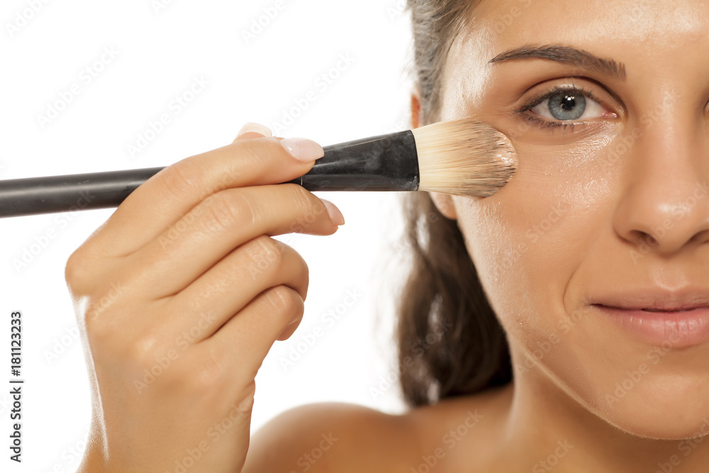 young beautiful woman applied liquid base with a brush