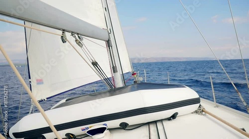 Sailing in Adriatic sea view from cockpit of sailing boat looking at front of boat and sails. Byboat tied up beside main mast. Filmed in slow motion hd.