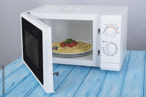 A new white microwave oven, on a blue wooden surface for heating food