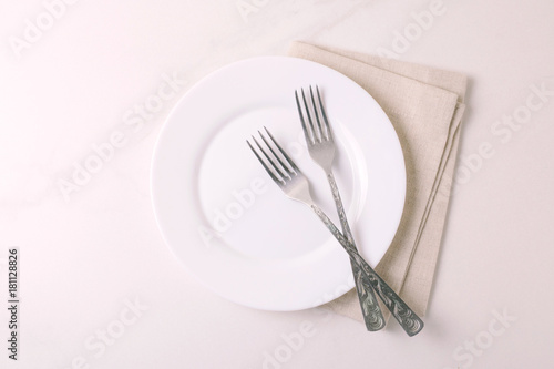Food background. White empty plate, cutlery, napkin. Top view, copyspace.