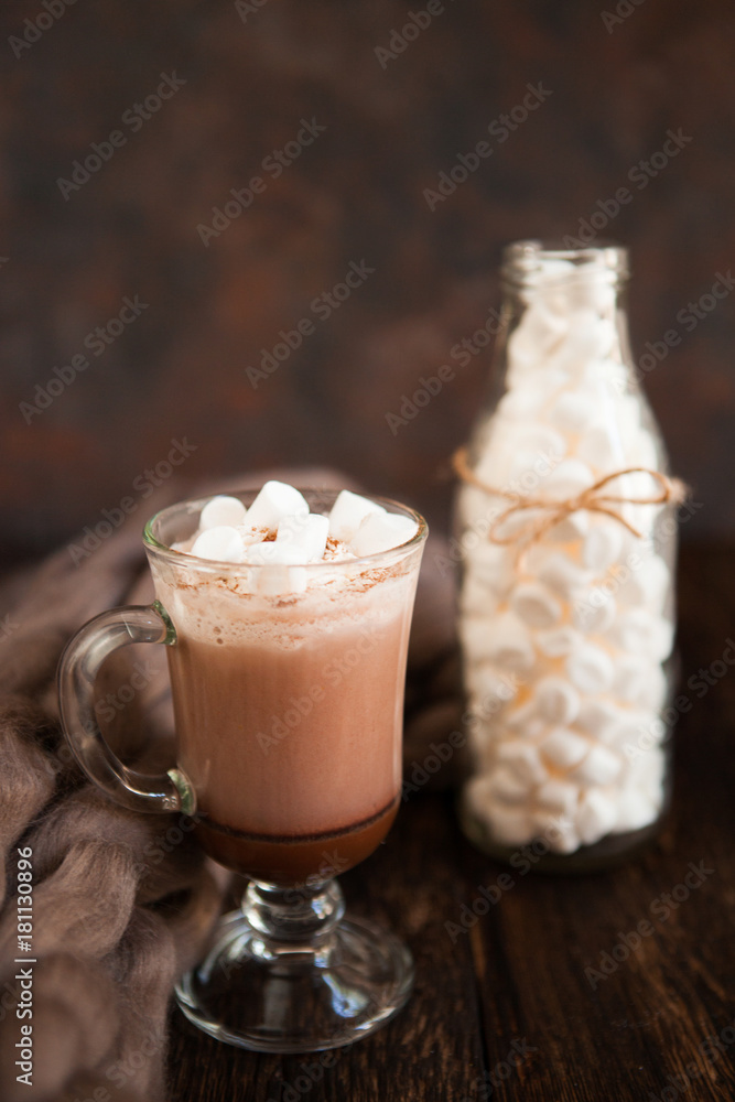 Two glasses with Hot chocolate garnished with whipped cream, marsmallow and cocoa powder on wooden background with Cozy plaid from merinose wool Two glasses with Hot chocolate garnished with whipped cream, marsmallow and cocoa powder on wooden background with Cozy plaid from merinose wool