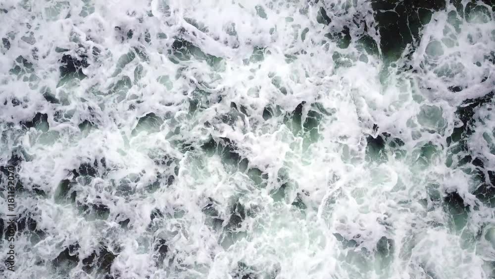 View of wave crashing on beach from above as it comes in and moves back to the ocean. View of wave crashing on beach from above as it comes in and moves back to the ocean.