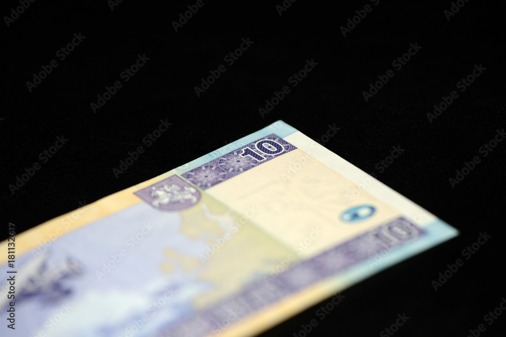 A banknote in ten Lithuanian litas on a dark background A banknote in ten Lithuanian litas on a dark background