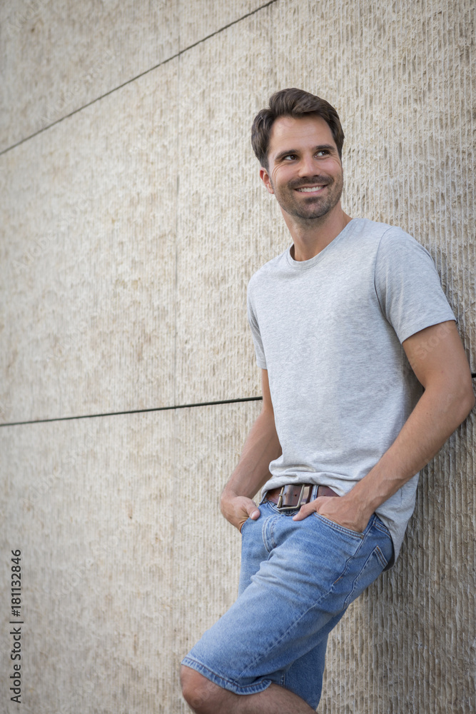 Man leaning against wall, smiling Man leaning against wall, smiling