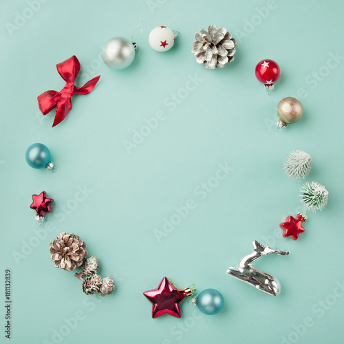 Circle frame of Christmas decorations on pale blue background, flatlay