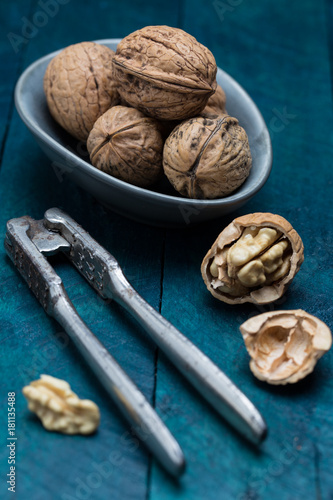 Walnuts on petrol-colored wood in bowl