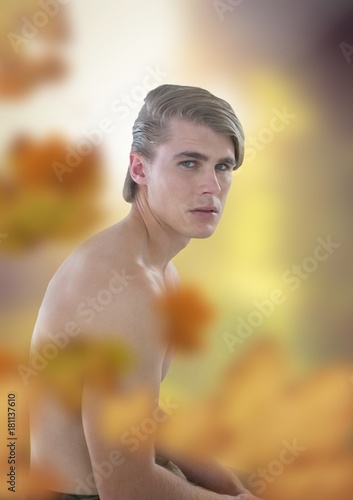 Nude handsome man in forest light opening with leaves