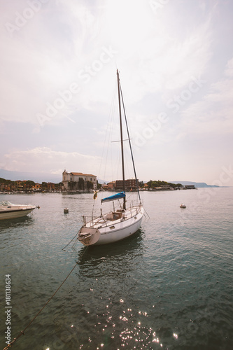 sunset on the lake lago di garda on the coast of salo boat near the pier on the background of the old city