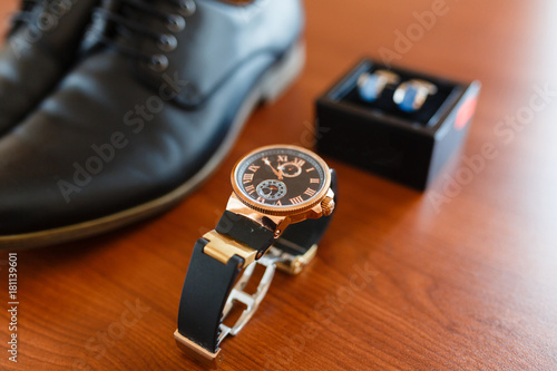 Set of the groom, expensive clock on the background of cufflinks in a box, classic leather shoes, mens accessories of a businessman on a wooden table. top view with place for text