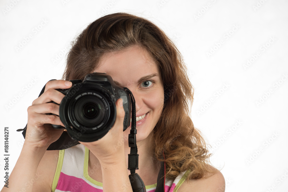 Young beautiful girl smiles and holds a camera on a white background Young beautiful girl smiles and holds a camera on a white background