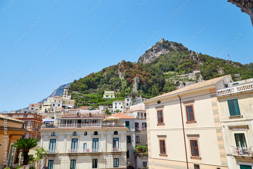 View of the city of Amalfi from the stairs of the local duomo in a summer clear sunny day with mountains in the background. Amalfi, Italy.