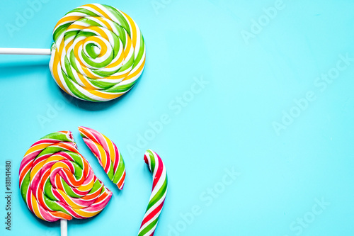 Delicious sugar lollipops on blue background top view space for 