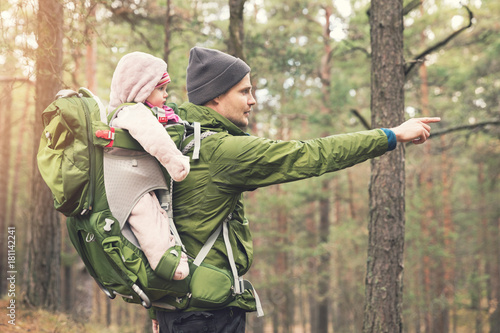 Photos father with baby in child carrier on a hike in the woods