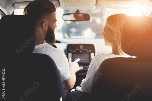 A young couple is sitting in the cabin of a comfortable modern electric car. © VadimGuzhva
