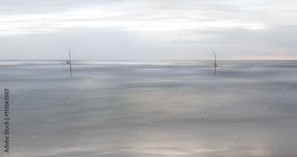 View of Indian ocean in blur and sticks of fishermen