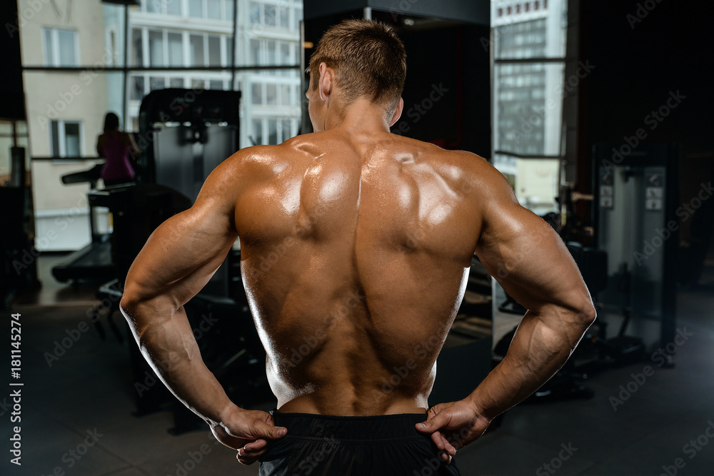 Handsome model young man training back in gym Handsome model young man training back in gym