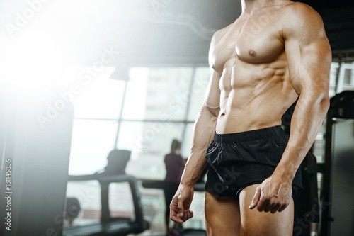 Handsome model young man training abs in gym