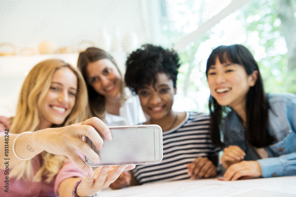 Friends using smartphone to take a selfie Friends using smartphone to take a selfie