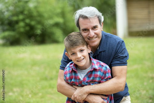 Wallpaper Mural Grandfather embracing grandson outdoors, portrait Torontodigital.ca