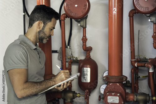 Man inspecting fire protection sprinkler system photo