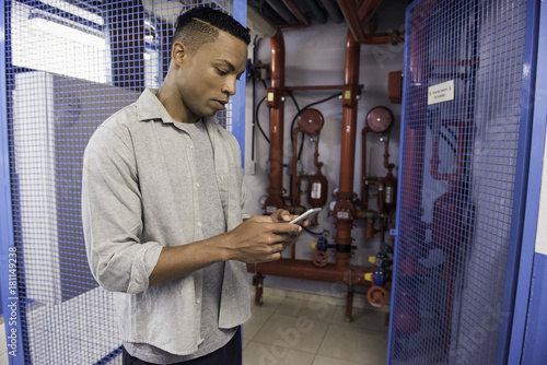 Man using mobile phone near fire protection sprinkler system