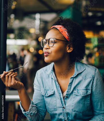Canvas Print Smiling young woman enjoying dinner alone in a bistro