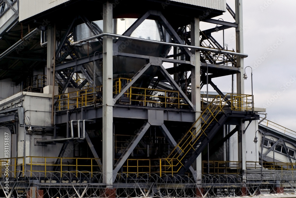 a fragment of a large industrial plant of a heavy industry factory with rack-beam structures and a steel tank.. a fragment of a large industrial plant of a heavy industry factory with rack-beam structures and a steel tank..