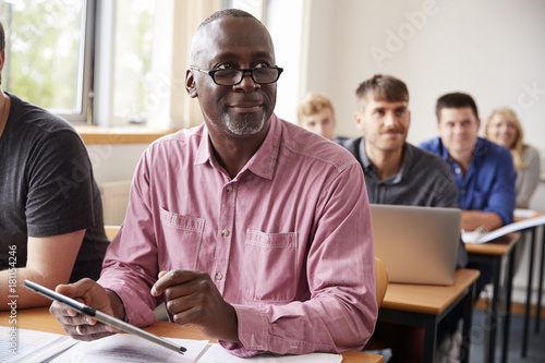 Mature Student Using Digital Tablet In Adult Education Class photo