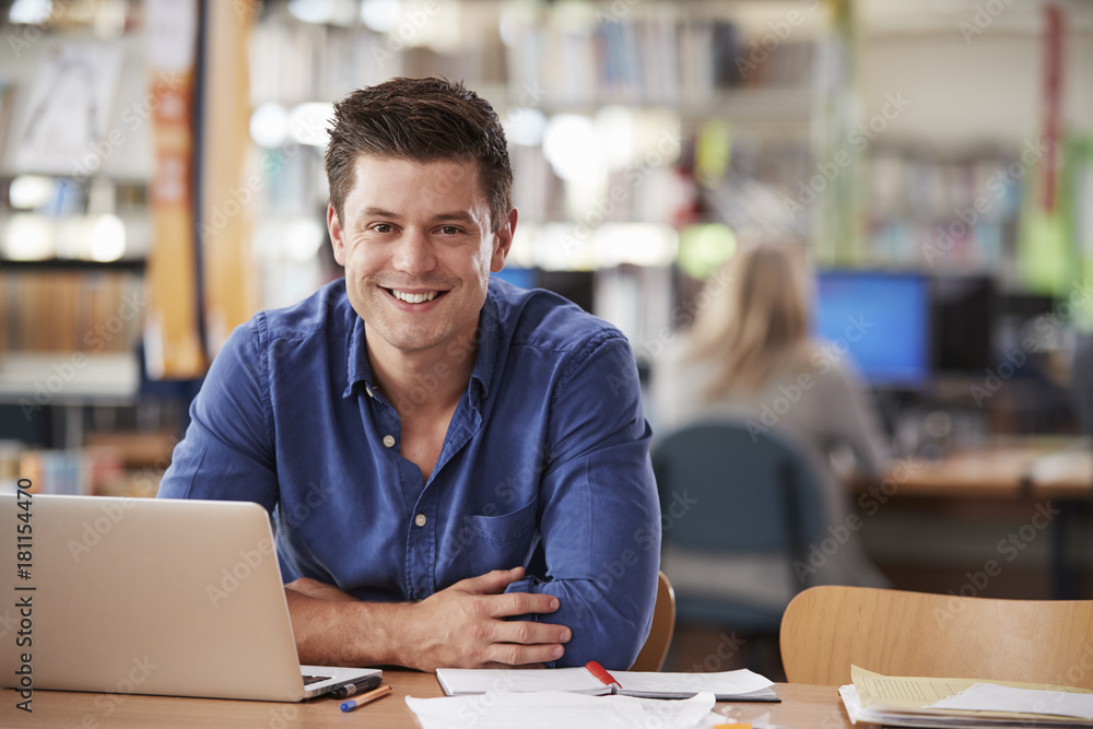 Portrait Of Mature Male Student Using Laptop In Library Portrait Of Mature Male Student Using Laptop In Library