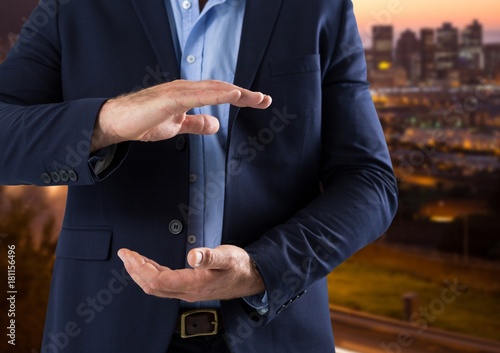 Businessman with hands palm open in city at evening