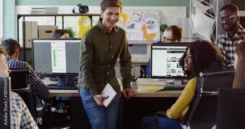 Young multi-ethnic office workers team discussing something in modern office space. Friendly atmosphere. Business team. photo