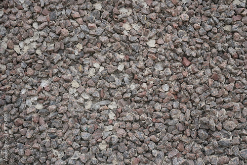 The texture of the stone. Small fragments. Flat view. Dark color. Granite. Uniform background.