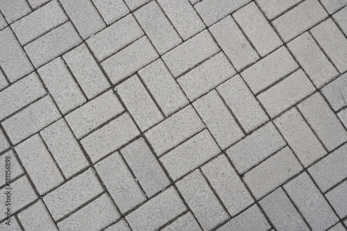 Light sidewalk tiles. View from above. Rectangular shapes. Diagonal lines. Grainy surface. Footpath. The city sidewalk.