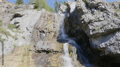 Big beautiful waterfall flows down the rocks mountains