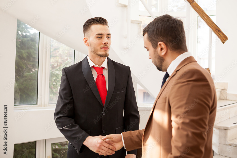 Two business men in office building shaking hands. Communication and deal Two business men in office building shaking hands. Communication and deal