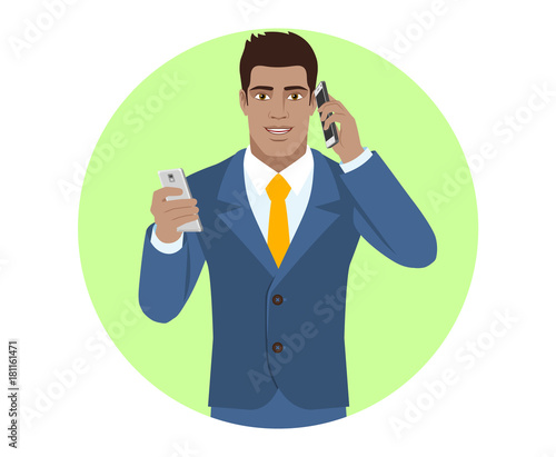 Businessman with mobile phone talking on the another mobile phone