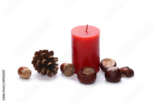 Extinguished red candle, chestnuts, acorn and pine cones isolated on white background