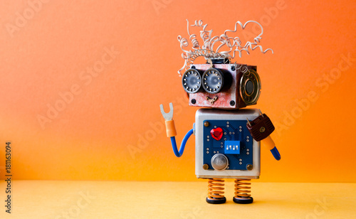 Friendly crazy robot handyman on orange background. Creative design cyborg toy. Copy space photo